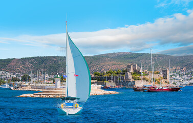 Lone white sail yact near Saint Peter Castle (Bodrum castle) and marina - Bodrum, Turkey
