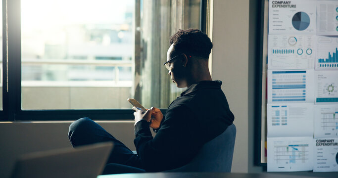 Phone, business and black man in office for financial forecast, company expenditure and graphs. Mobile, analyst and reading email for data analysis, investment trends or review chart for kpi online