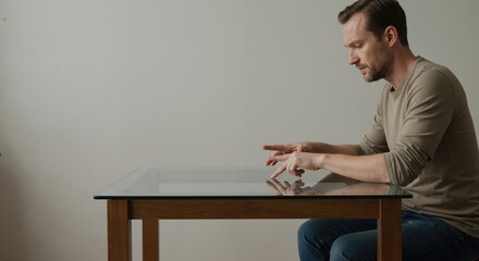 Man interacting with a futuristic virtual interface on a glass table. Advanced technology and innovation concept. User operating an interactive smart surface with copy space.