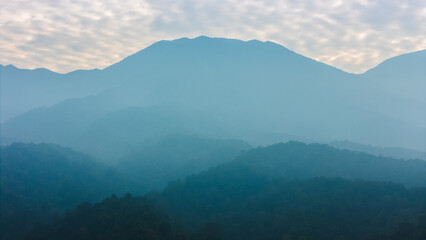 Beautiful mountain landscape with layers of mist covering the peaks, creating a calm natural scene.