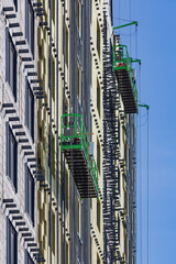 Construction baskets for work on the facade of a multi-storey building under construction