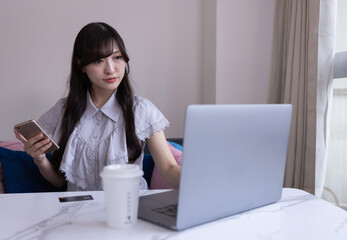 A Japanese woman working by laptop in the living room