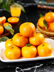 Fresh Small Seedless Oranges from Guangxi Sihui China on White Plate with Orange Juice