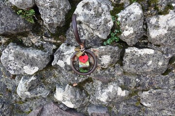 a rusty round handle attached to a stone wall