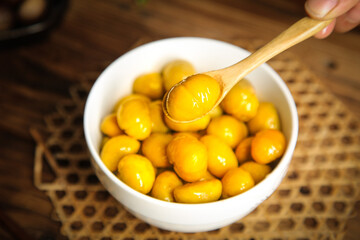 Fresh Golden Chestnuts in Bowl with Wooden Spoon - Raw Organic Nuts Ready for Cooking