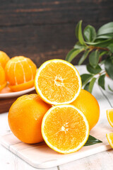 Fresh Navel Orange Halves on Cutting Board with Green Plant - Healthy Citrus Fruit Display