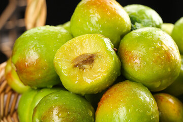 Large Green-Skinned Pears from Xinjiang Displayed in Wooden Basket with Cut Half Showing Interior