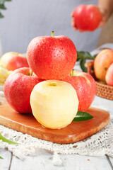 Fresh Red Fuji Apples on Wooden Board with Peeled Apple Showing White Flesh