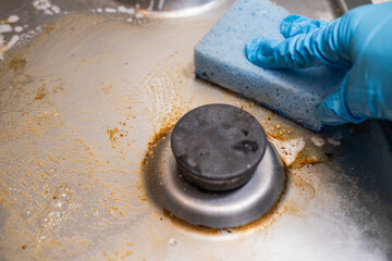 Dirty stove with food leftovers. Unclean gas kitchen cooktop with greasy spots, old fat stains, fry spots and oil splatters.