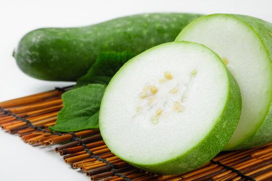 Fresh Winter Melon and Hairy Knob Gourd Slices Display on Bamboo Mat with Seeds Visible