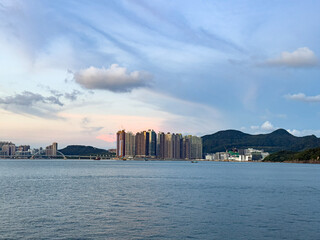 Obraz premium Hong Kong Cityscape and Skyline Across the Sea at Sunset