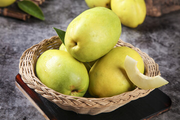 Fresh Green Mangoes in Wicker Basket - Tropical Fruit on Rustic Wood Surface
