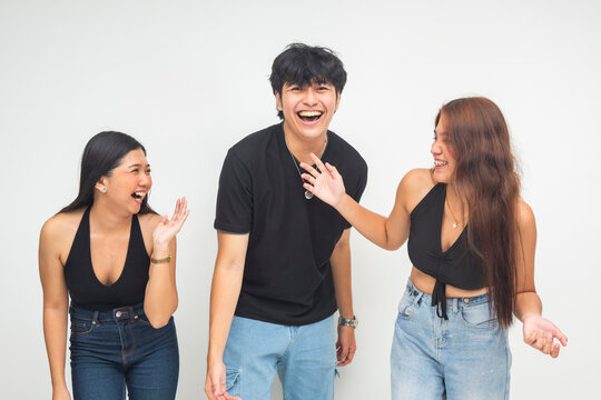 Three cheerful young Asian friends laughing and giggling while spending time together, clearly enjoying each other's company and having fun. Isolated on a white background.