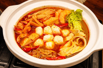 Asian Hot Pot with Fish Balls and Vegetables in Spicy Broth