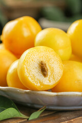 Fresh Xinjiang Apricots in White Bowl - Organic Yellow Stone Fruit Cut in Half Showing Pit and Juicy Flesh