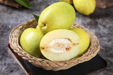 Fresh Yunnan Green Papaya Fruits in Wicker Basket with Cut Half Showing White Flesh and Seeds