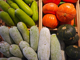 Fresh Cucumbers and Pumpkins Arranged in Wooden Crates