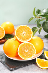Fresh Orange Citrus Fruits Cut in Half on White Plate with Green Leaves Natural Healthy Produce