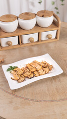 Fresh Golden Matsutake Mushroom Slices with Herbs on White Plate in Modern Kitchen