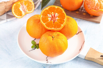 Fresh citrus oranges on marble plate with wooden cutting board - healthy fruit arrangement