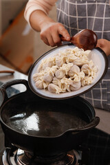 Chef Cooking Fresh Handmade Ravioli Pasta in Steamer Over Clear Broth