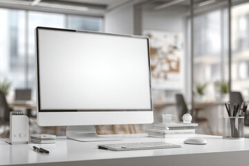 Fototapeta premium blurred background of a modern office interior with a white desk and computer monitor mockup, a minimalist work space for a graphic designer or web developer, with copy space.