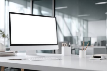 Fototapeta premium blurred background of a modern office interior with a white desk and computer monitor mockup, a minimalist work space for a graphic designer or web developer, with copy space.