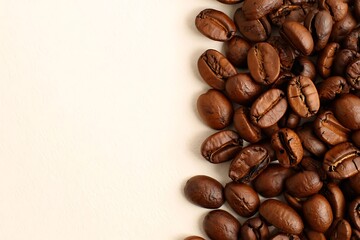Obraz premium Roasted Coffee Beans Background with Beige Space for Text or Design for Coffee Lovers and Business Use
