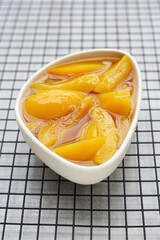 Sliced peaches in syrup served in a bowl