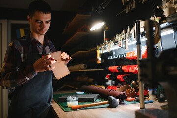 Portrait of handsome tanner man at work, small business, authentic workshop, indoors. leather goods.