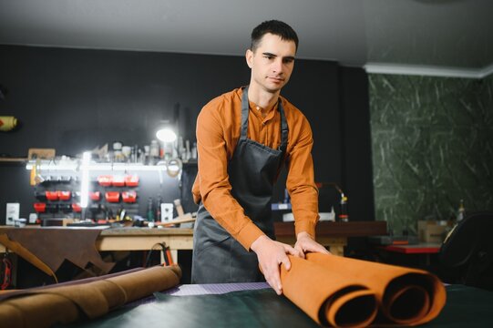 Portrait of handsome tanner man at work, small business, authentic workshop, indoors. leather goods.