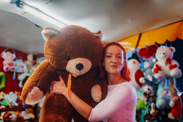 Woman winning a giant teddy bear at amusement park