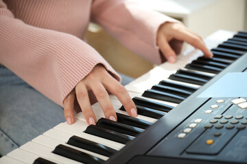 Obraz premium Woman learning to play piano indoors, closeup