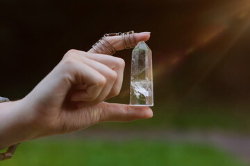Obraz premium Woman meditating with crystal to heal or restore her aura outdoors, closeup