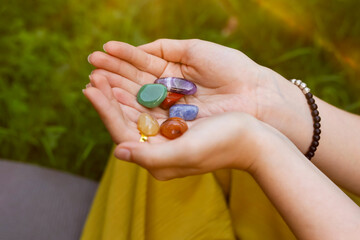Woman meditating with crystals to heal or restore her aura outdoors, closeup