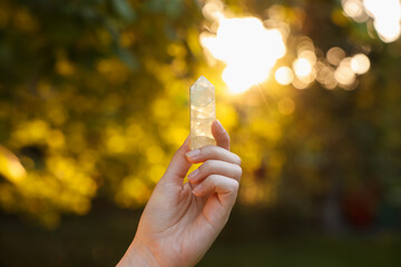 Woman meditating with crystal to heal or restore her aura outdoors, closeup