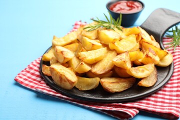 Tasty baked potatoes with rosemary on light blue wooden table, closeup