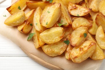 Tasty baked potatoes with parsley on white wooden table, above view