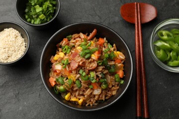 Delicious fried rice in bowl served on grey textured table, flat lay