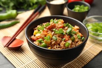 Delicious fried rice in bowl served on grey table, closeup