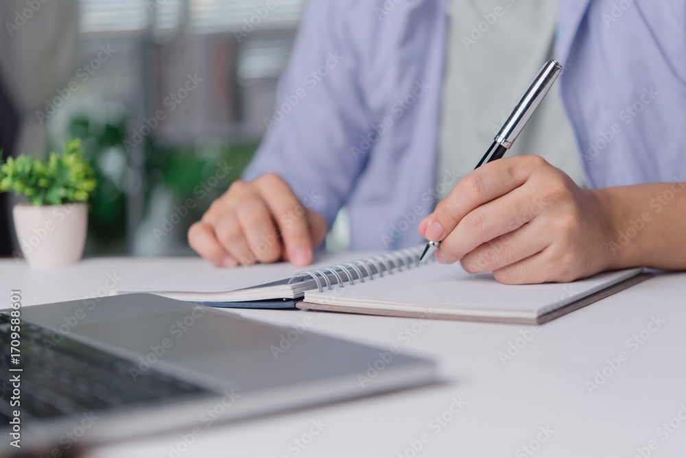 Poster freelancer taking notes at tidy desk with notebook laptop, home office setup for planning workflow p