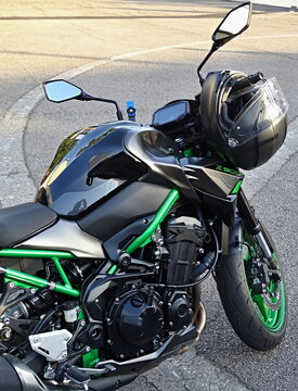 Kawasaki Z900 motorcycle parked on asphalt with helmet resting on handlebar