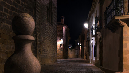 A narrow alleyway of a medieval town by night