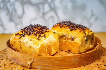 Indonesian bolen pastry with golden crust, chocolate sprinkles, and rich filling served on bamboo tray highlighting flaky layers, sweet texture, and traditional snack appeal for food styling.