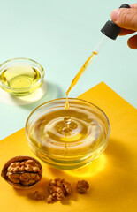 Pouring Walnut Oil into Glass Bowl with Walnuts