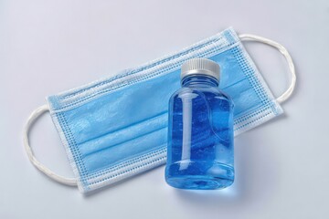 Essential healthcare items including a blue medical mask and a sanitizing gel bottle exemplifying wellness, hygiene, and safety in today's health-conscious society