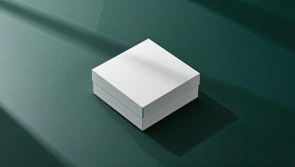 Sitting closed white square box on dark green studio surface, casting diagonal light and shadow