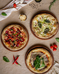 This photograph showcases three different delicious pizzas, highlighting the art of traditional Italian cuisine. It's a perfect visual for menu designs, restaurant advertisements, and food magazines.