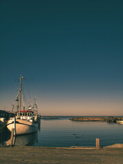 Fishing boats in the harbor under clear skies and calm water