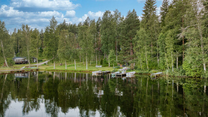 Quiet forest lake with boats and jetties, natural idyll for relaxation & leisure